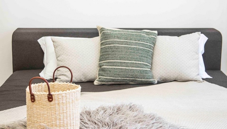 Fotografia z kalendára, ktorý bol vydaný pri príležitosti 75. výročia výročia Ústredia ľudovej umeleckej výroby, ktorý zachytáva tradičné ľudovoumelecké výrobky v moderných priestoroch; tkaný zelený poťah na vankúš, výroba Halina Grešlíková; šúpoľový košík, výroba Valéria Gyűrűsiová a guba, výroba Ján Fotta, zdroj: FB ÚĽUV