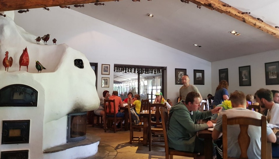 Súčasná fotografia Salaša Krajinka – interiér reštaurácie. V pozadí sú zasklenia, cez ktoré je možné vidieť ovce v maštali, foto: https://www.salaskrajinka.sk/